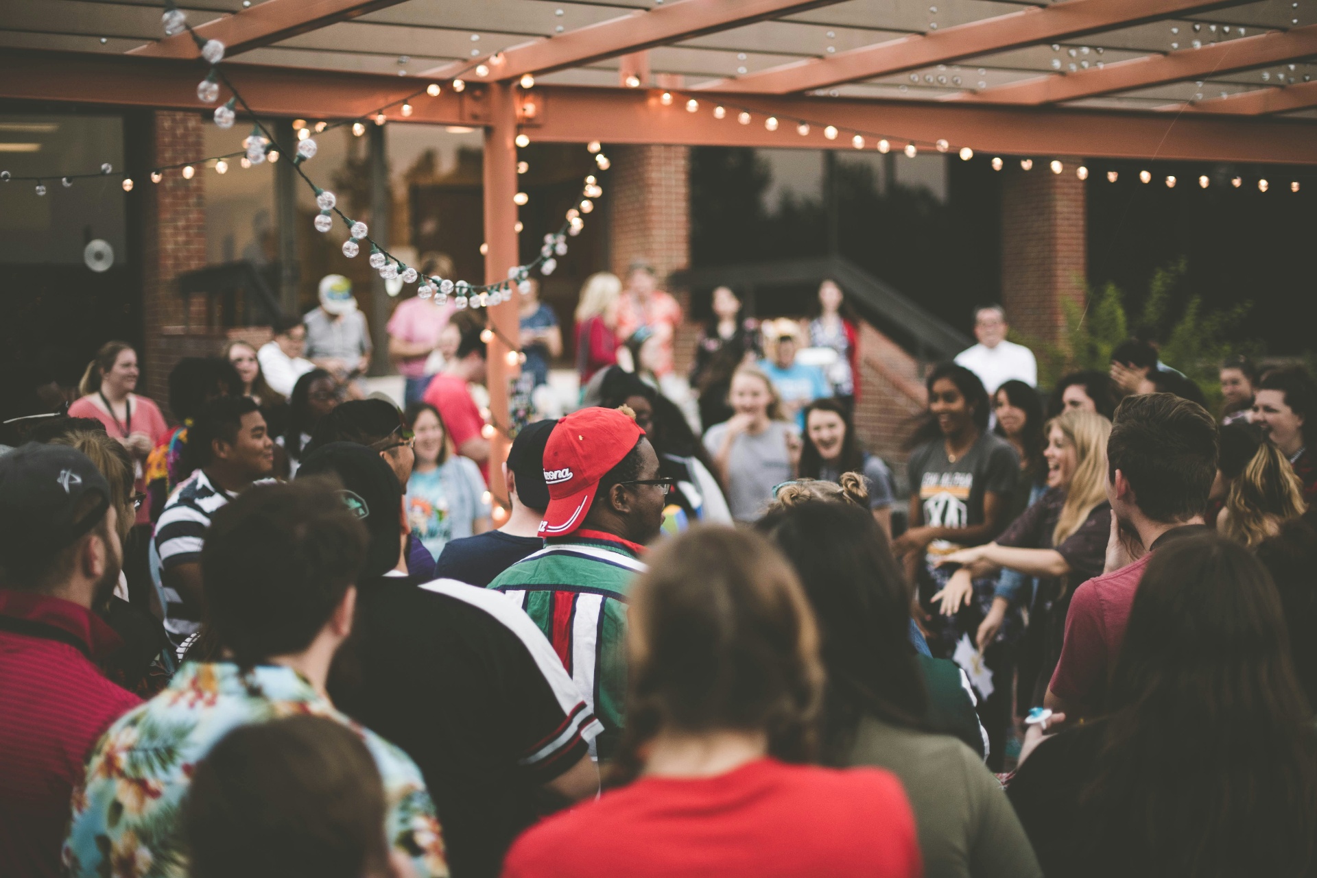 Crowd socialising under festoon lights